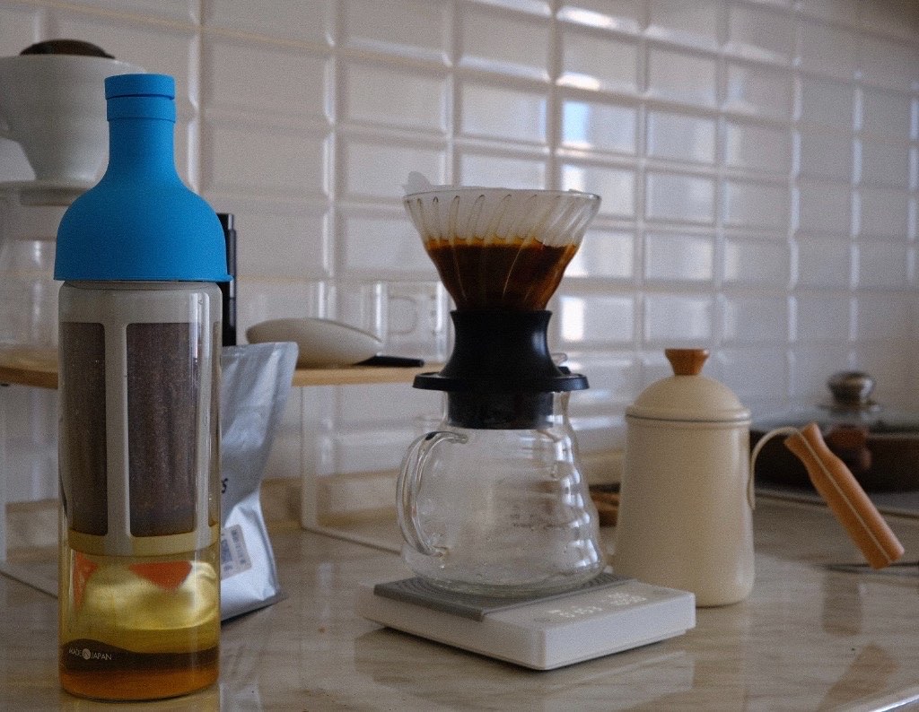 Бутылка Hario Filter-in с завариваемым cold brew рядом с пуровером V60